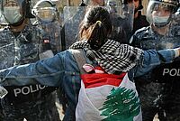 Masked riot police are confronted by one of many protesters who broke lockdown to protest deteriorating living conditions in Beirut, Lebanon, Tuesday, April 28, 2020 -Copyright AP Photo/Hussein Malla